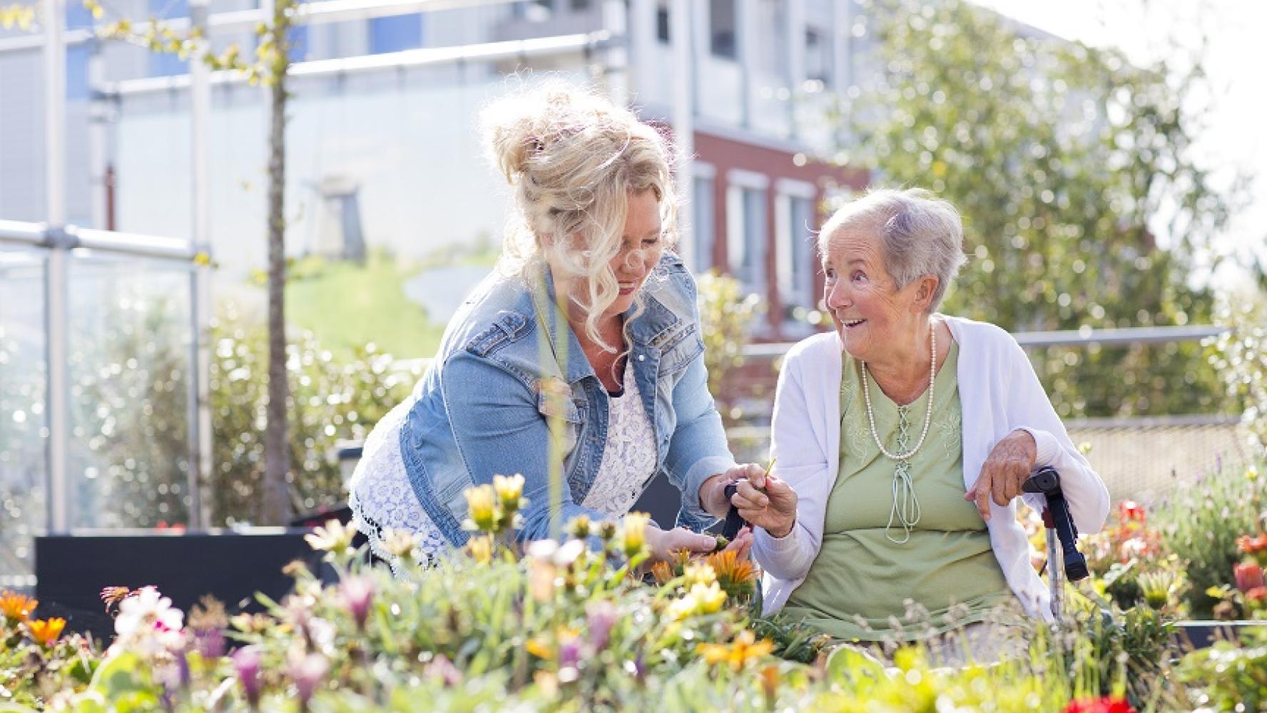 Bewoner en medewerker in de tuin