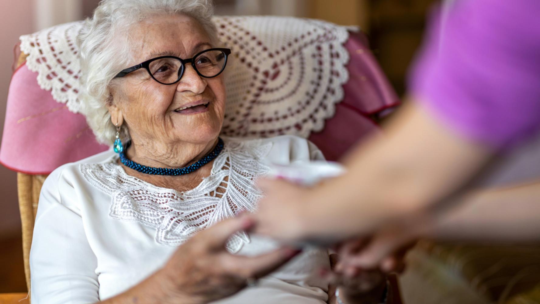 Lachende mevrouw met zorgmedewerker